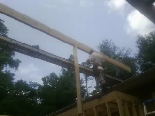 Carpenter setting a ridge beam over a new addition frame — Ice Dam Removal by Roofing Brothers in Ardmore